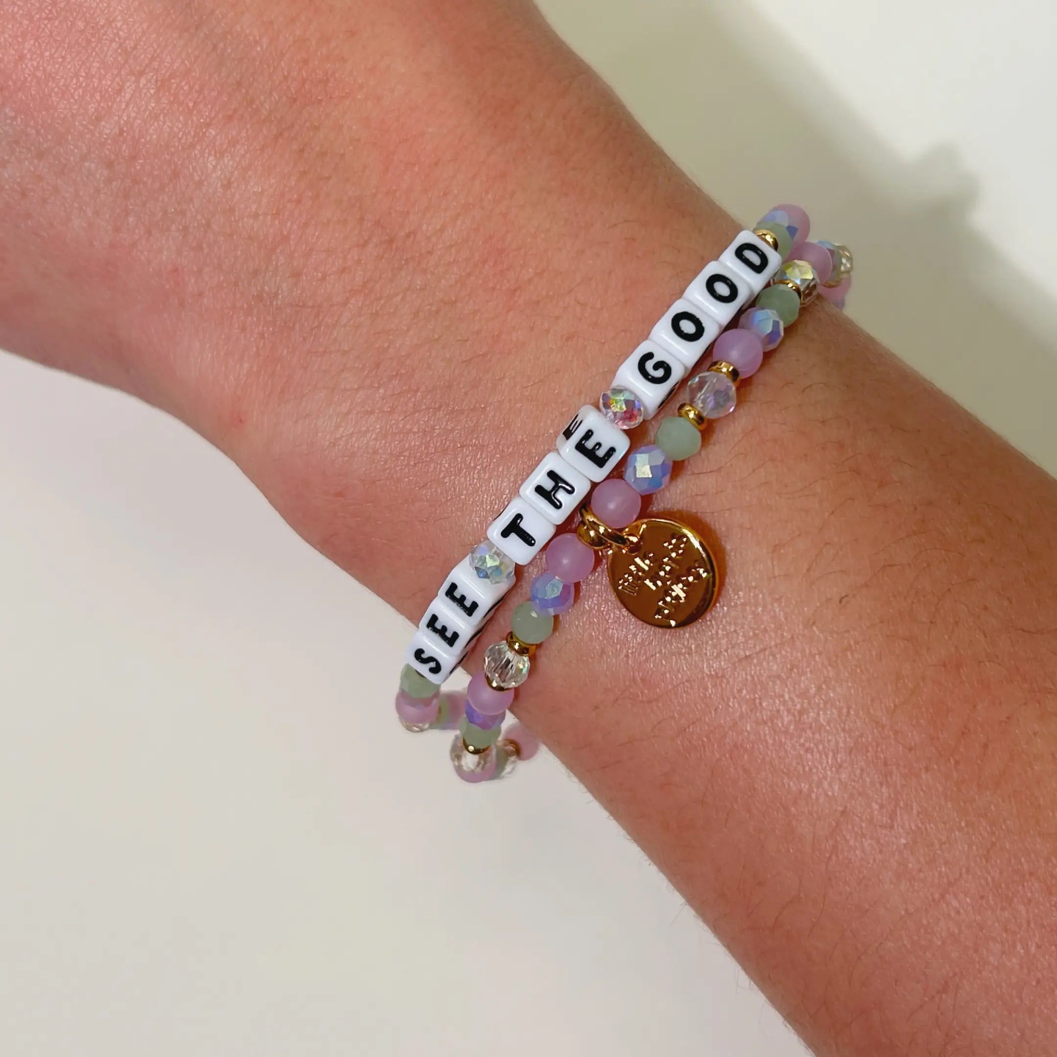 Bracelet with 'See the Good' message on a wrist against a neutral background