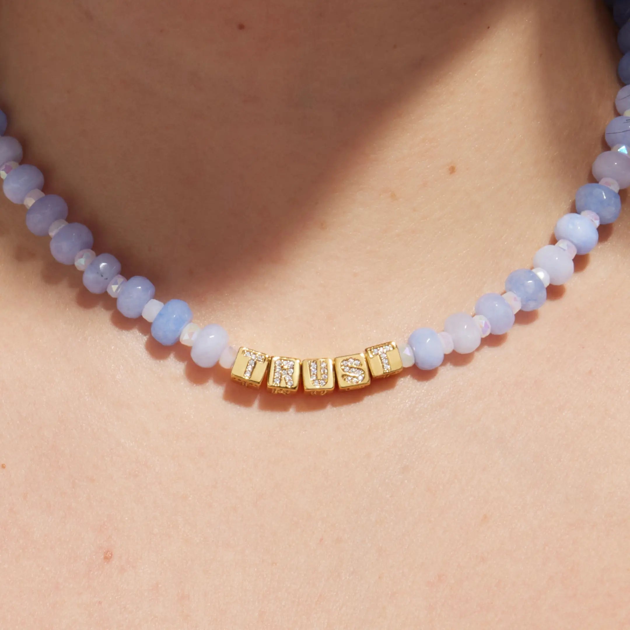 Necklace with blue beads and gold accents on a person's neck