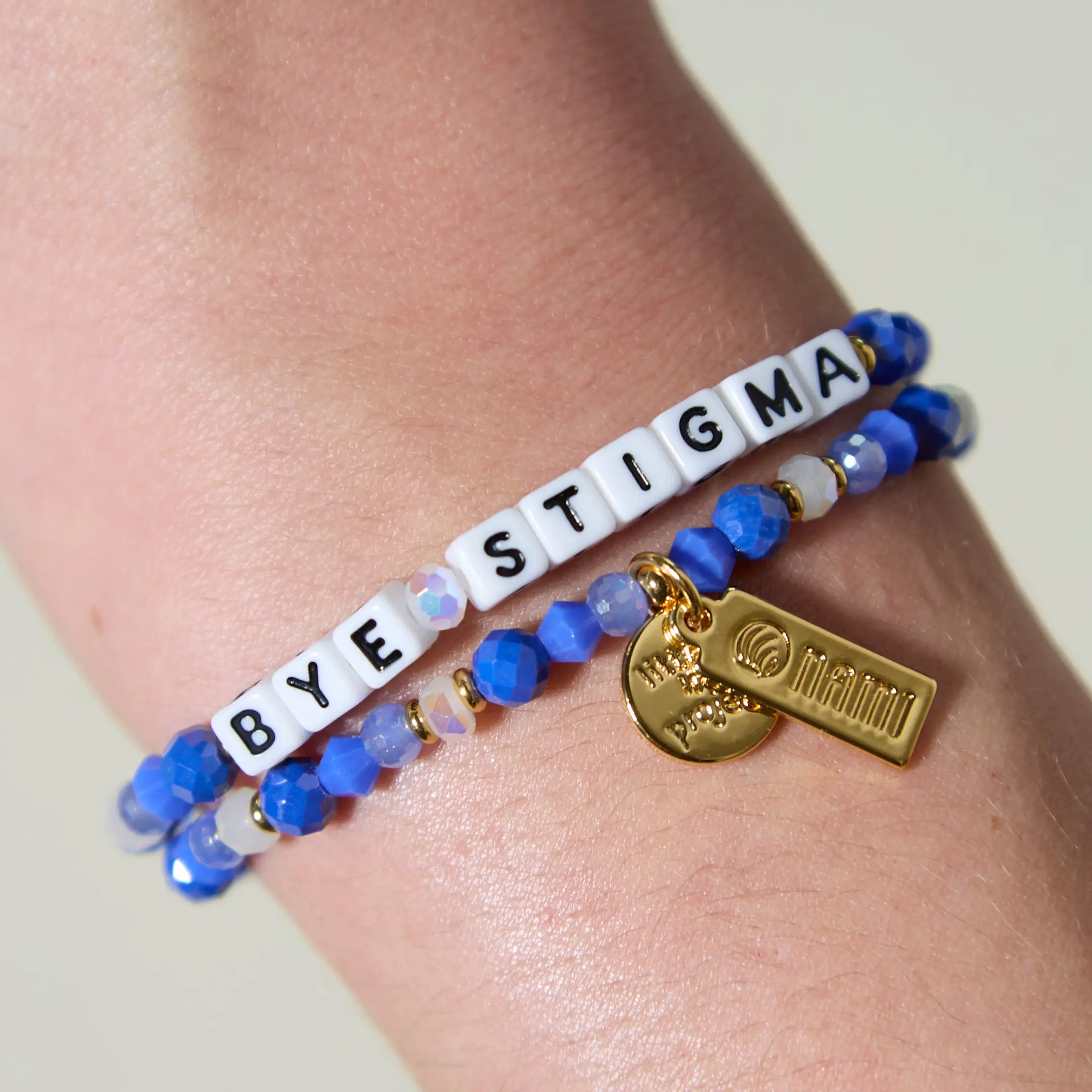 Bracelet with 'BYE STIGMA' beads on a wrist