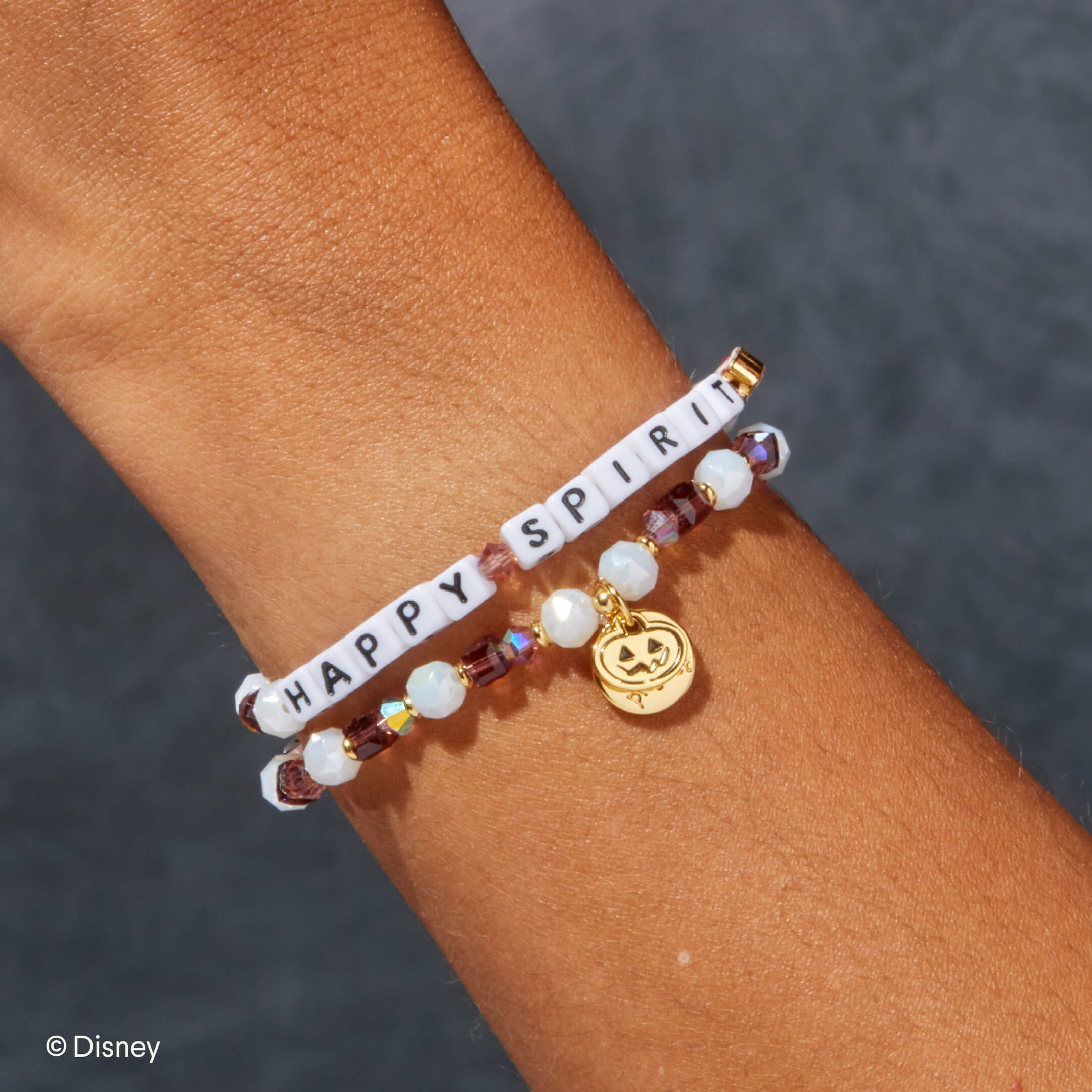 Bracelet with 'Happy Spirit' on a wrist against a dark background