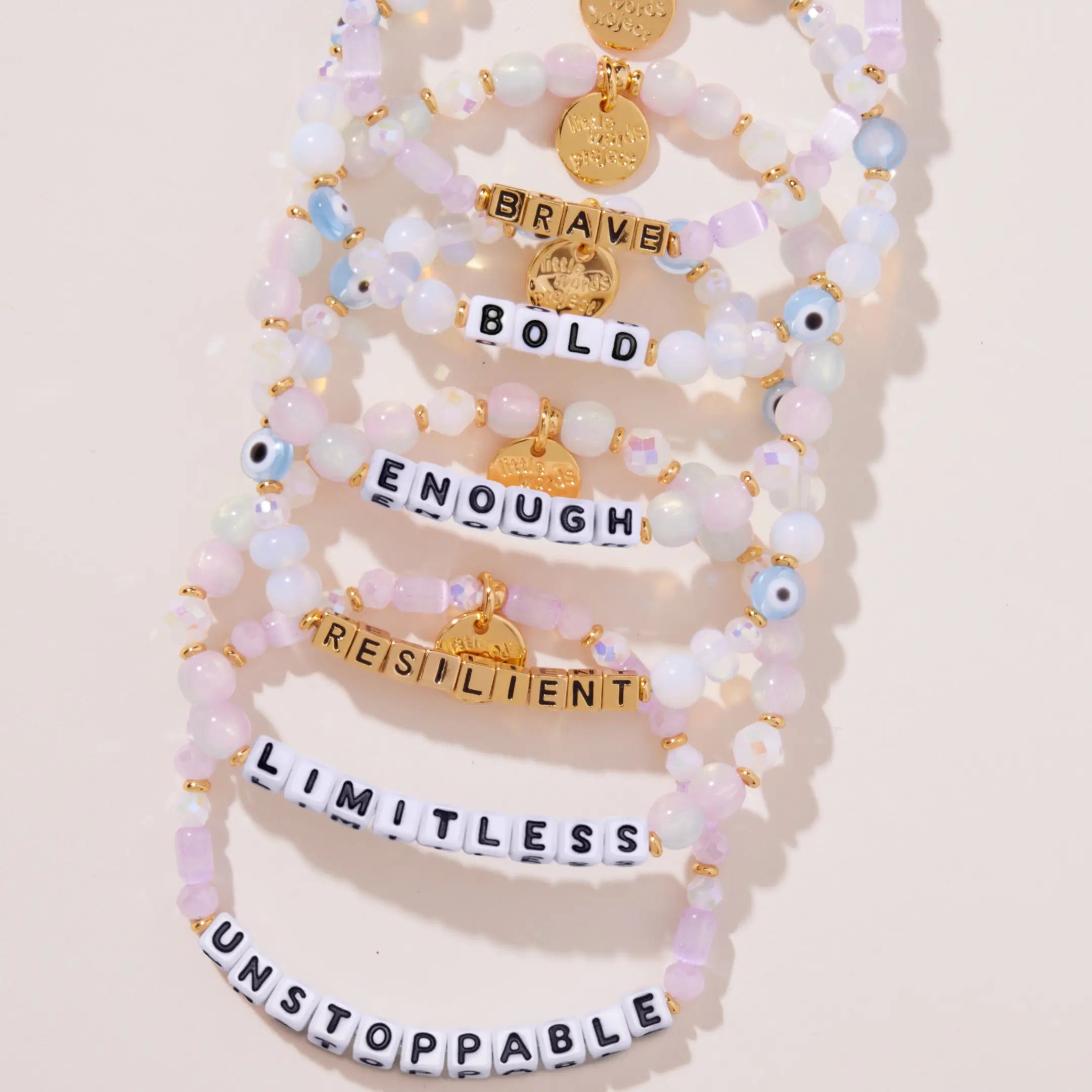Set of beaded bracelets with motivational phrases on a light background
