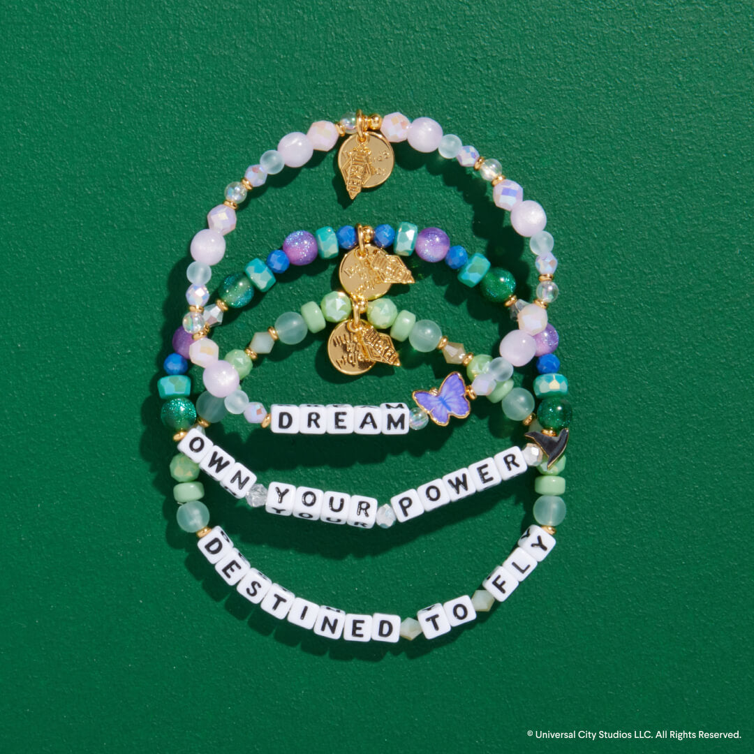 Set of beaded bracelets with motivational phrases on a green background