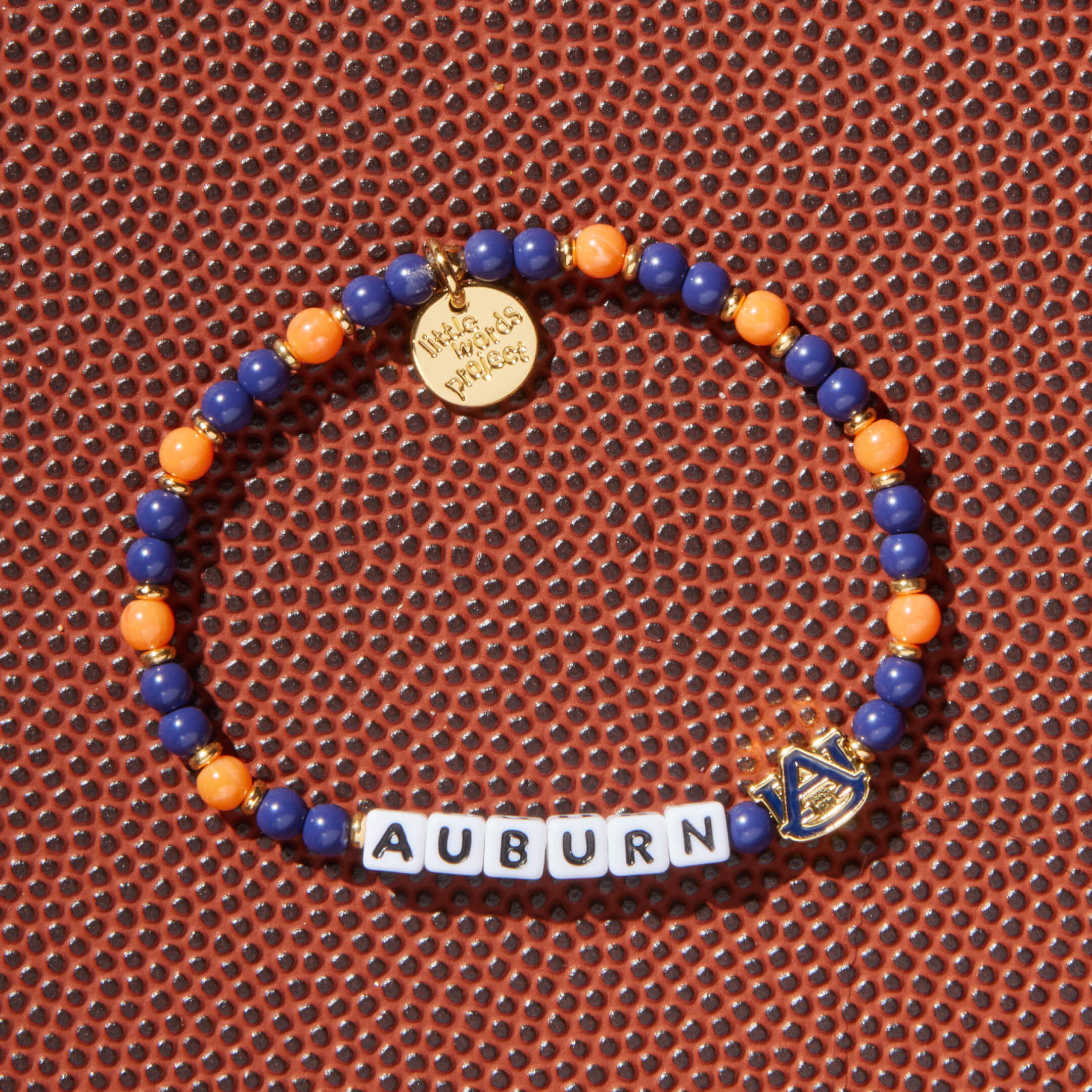 Bracelet with blue and orange beads and 'Auburn' letters on a football background