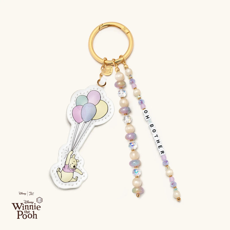 Bag charm with Winnie the Pooh holding balloons and "Oh Bother" word.