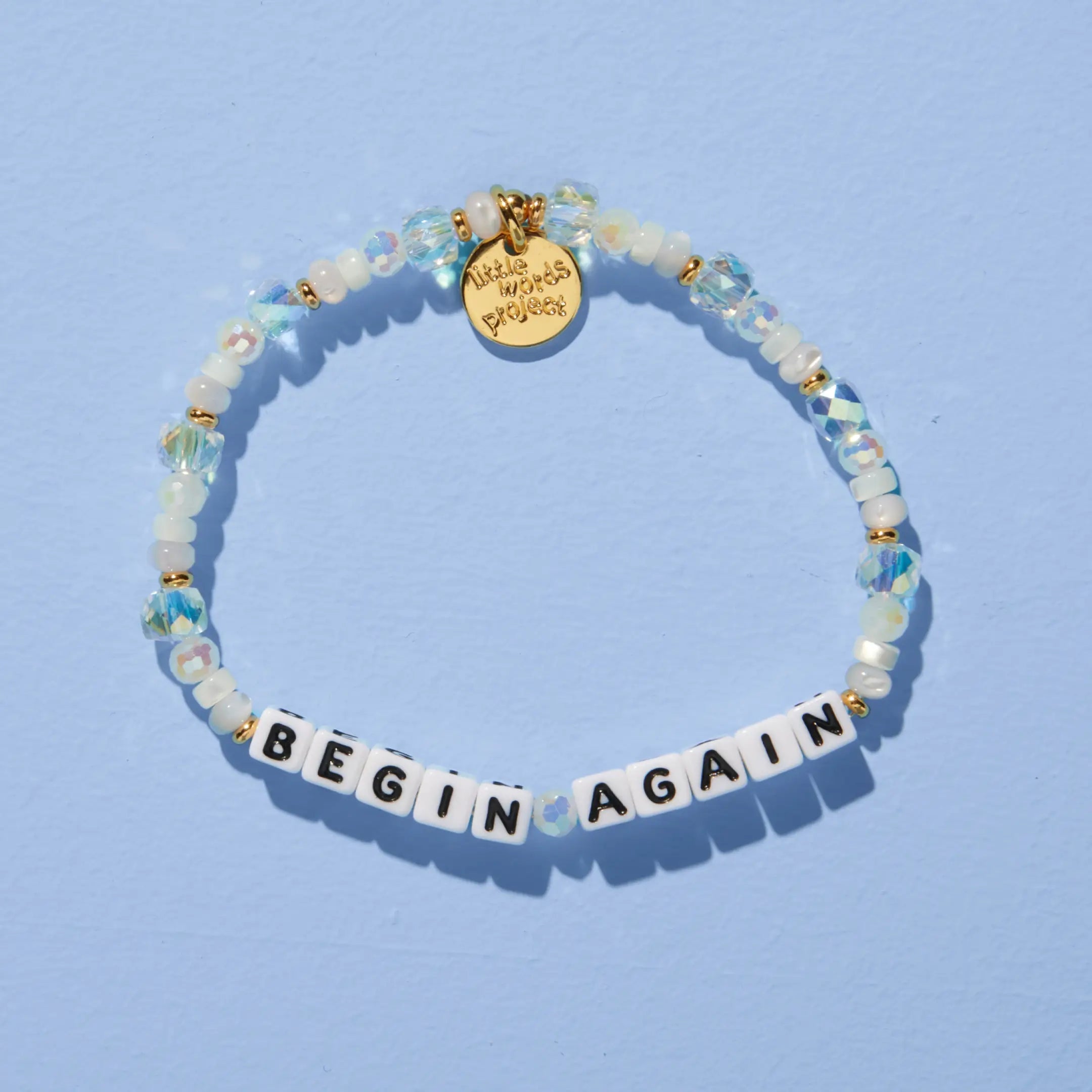 Begin Again — on-model shot of beaded word bracelet stacked on wrist