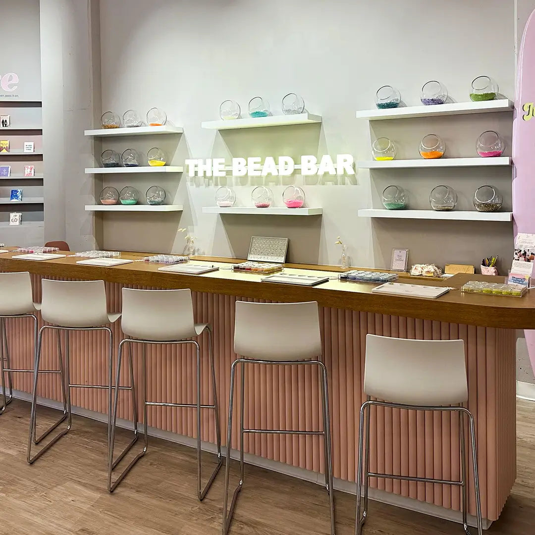 Bead bar with shelves displaying various colored beads and a counter with tools.