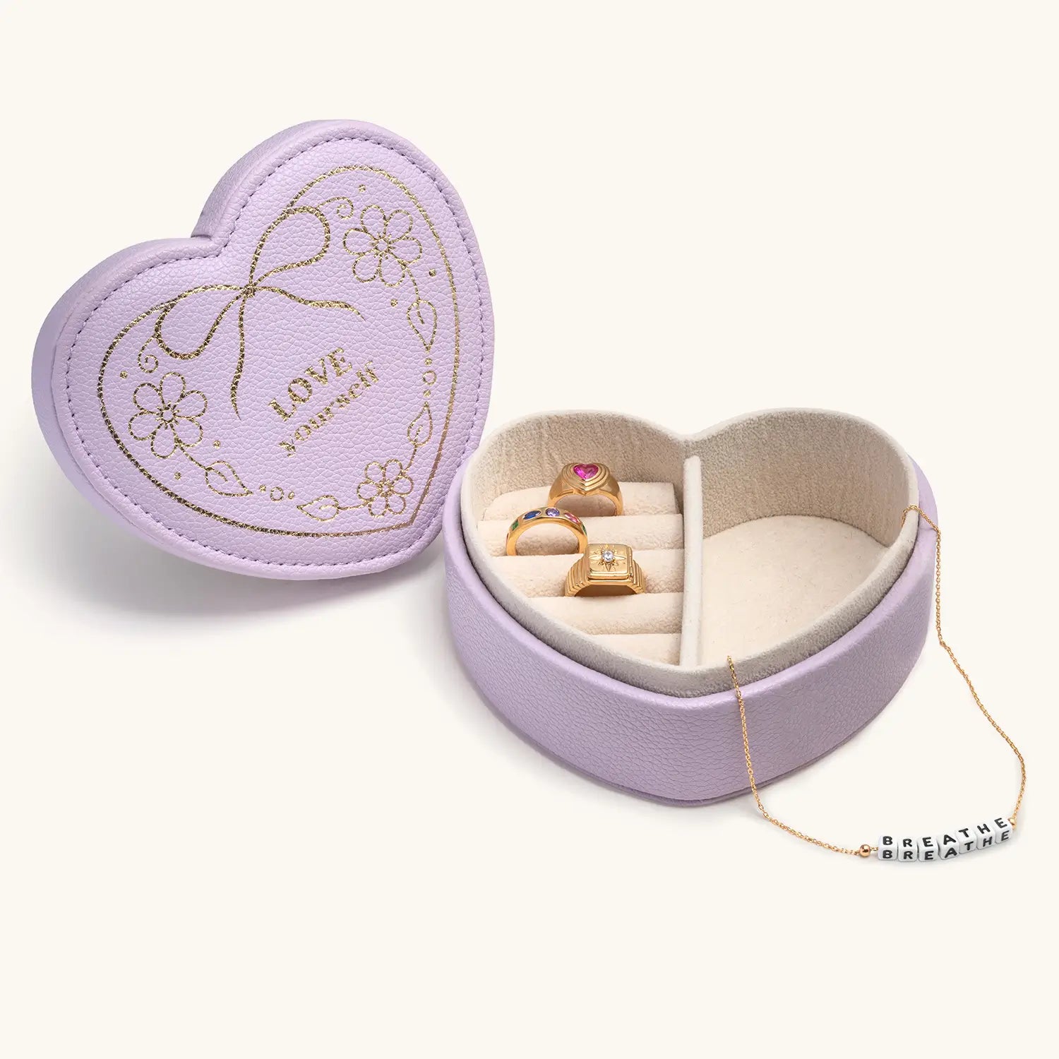 Heart-shaped jewelry box with rings and a necklace on a white background