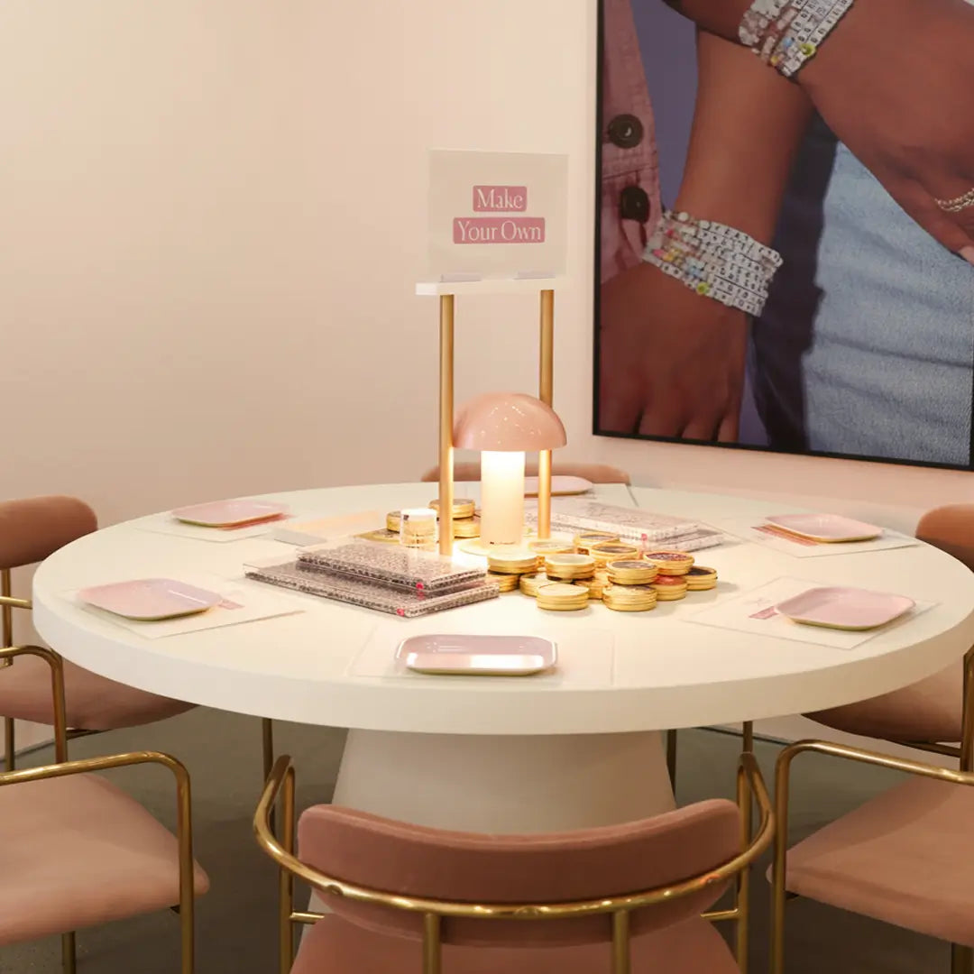 Round table with decorative items in a room with a person and a mirror in the background