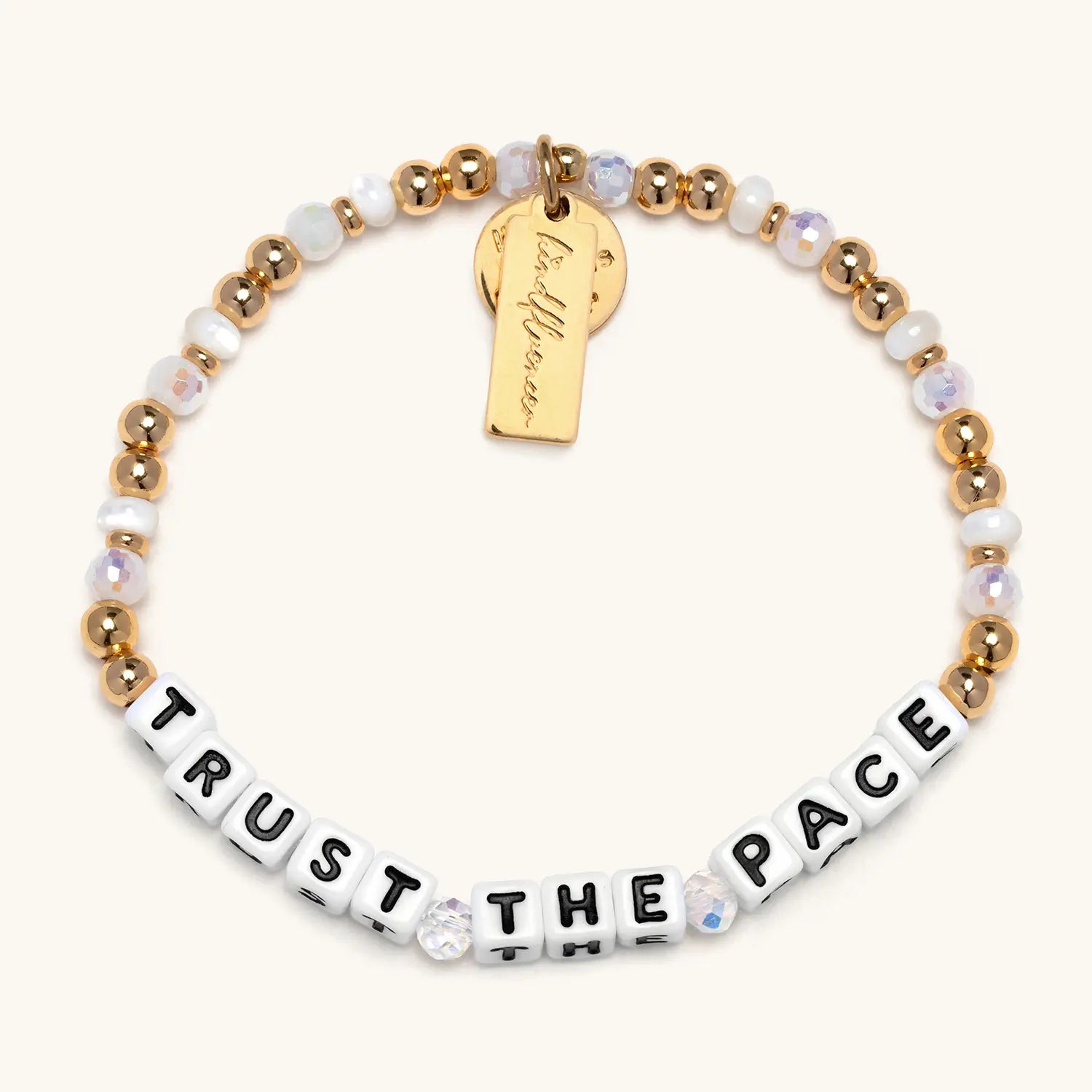 Bracelet with gold and white beads and motivational message on a white background