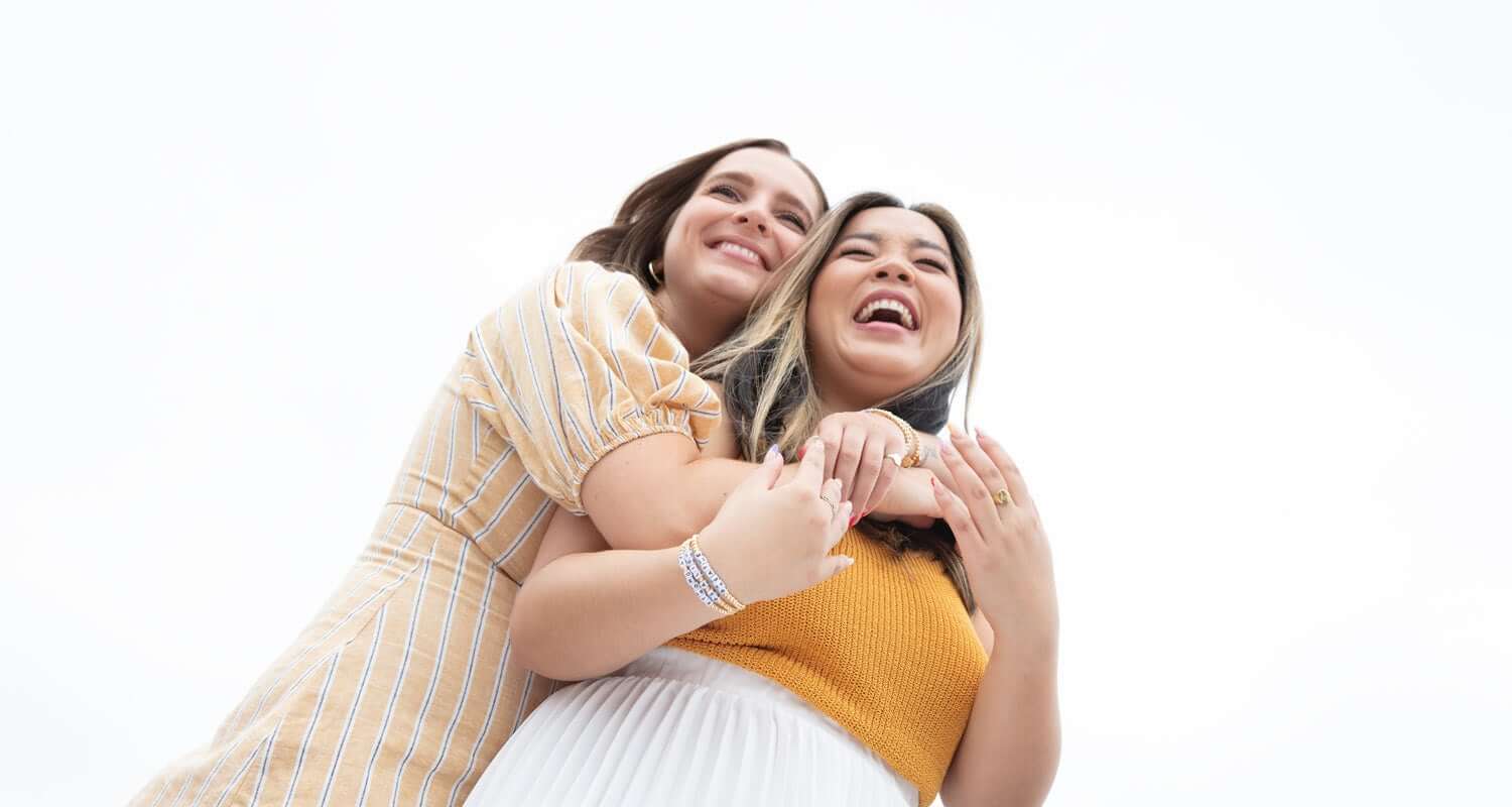 Friends Hugging Wearing Little Words Project Bracelets