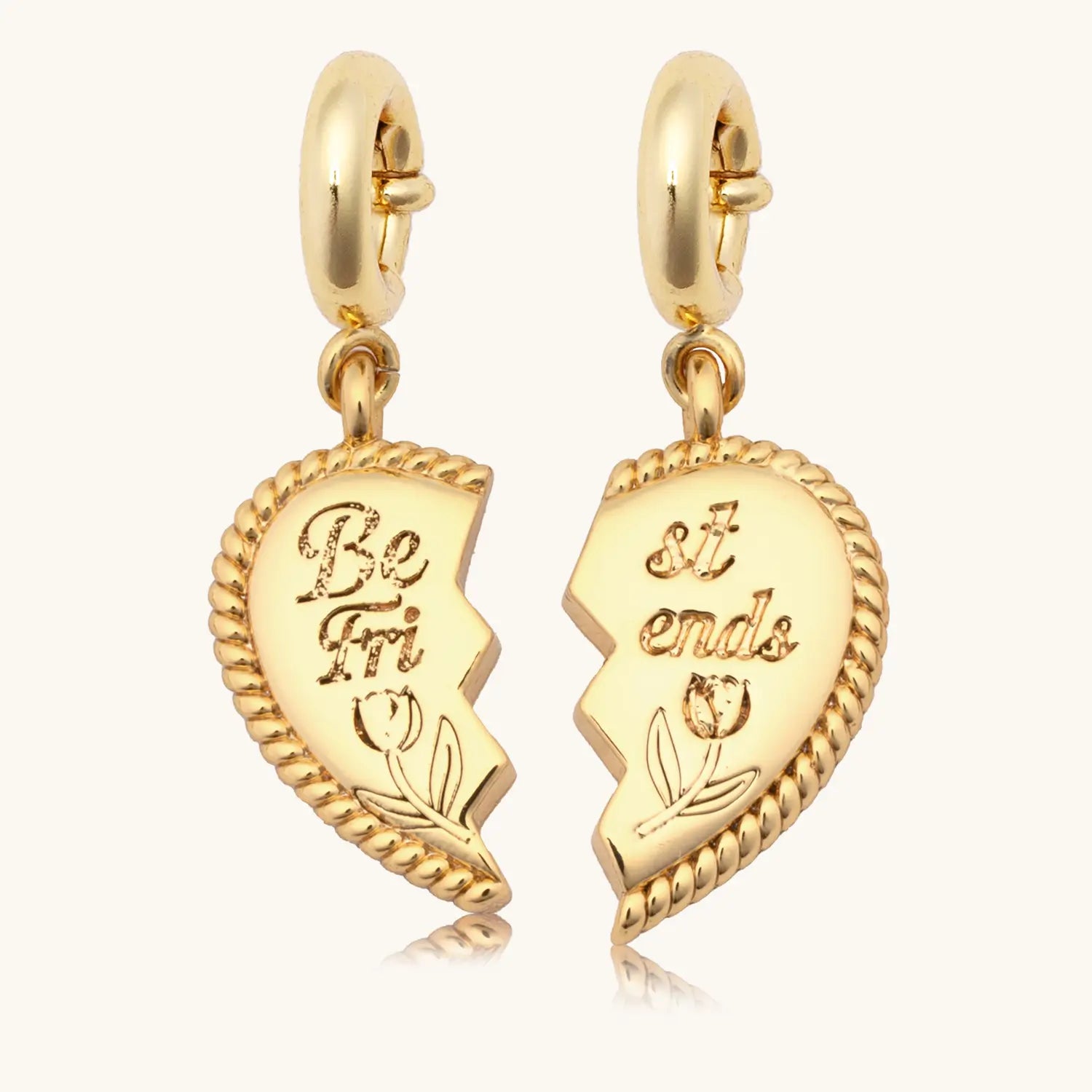 Gold heart-shaped charms with engraved text on a white background