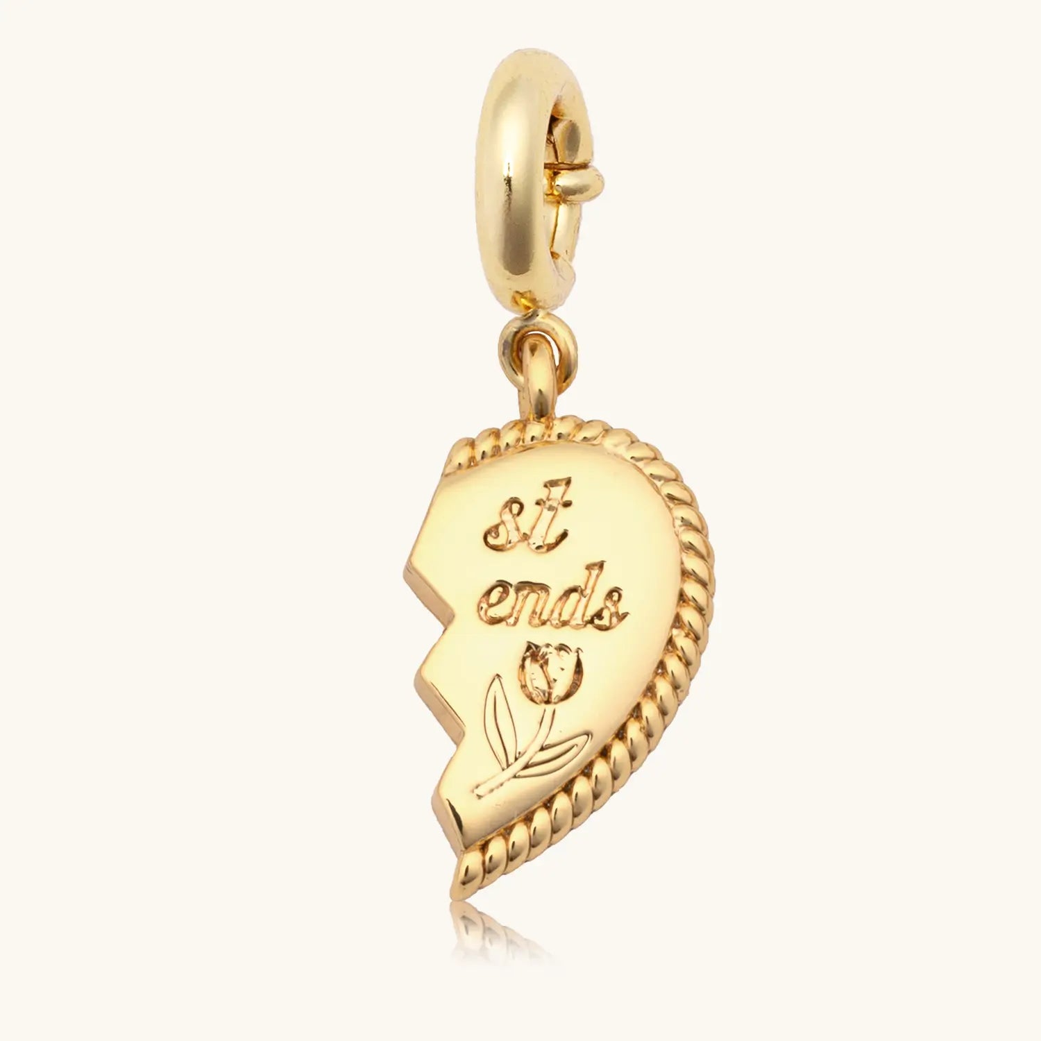 Gold charm with text on a white background