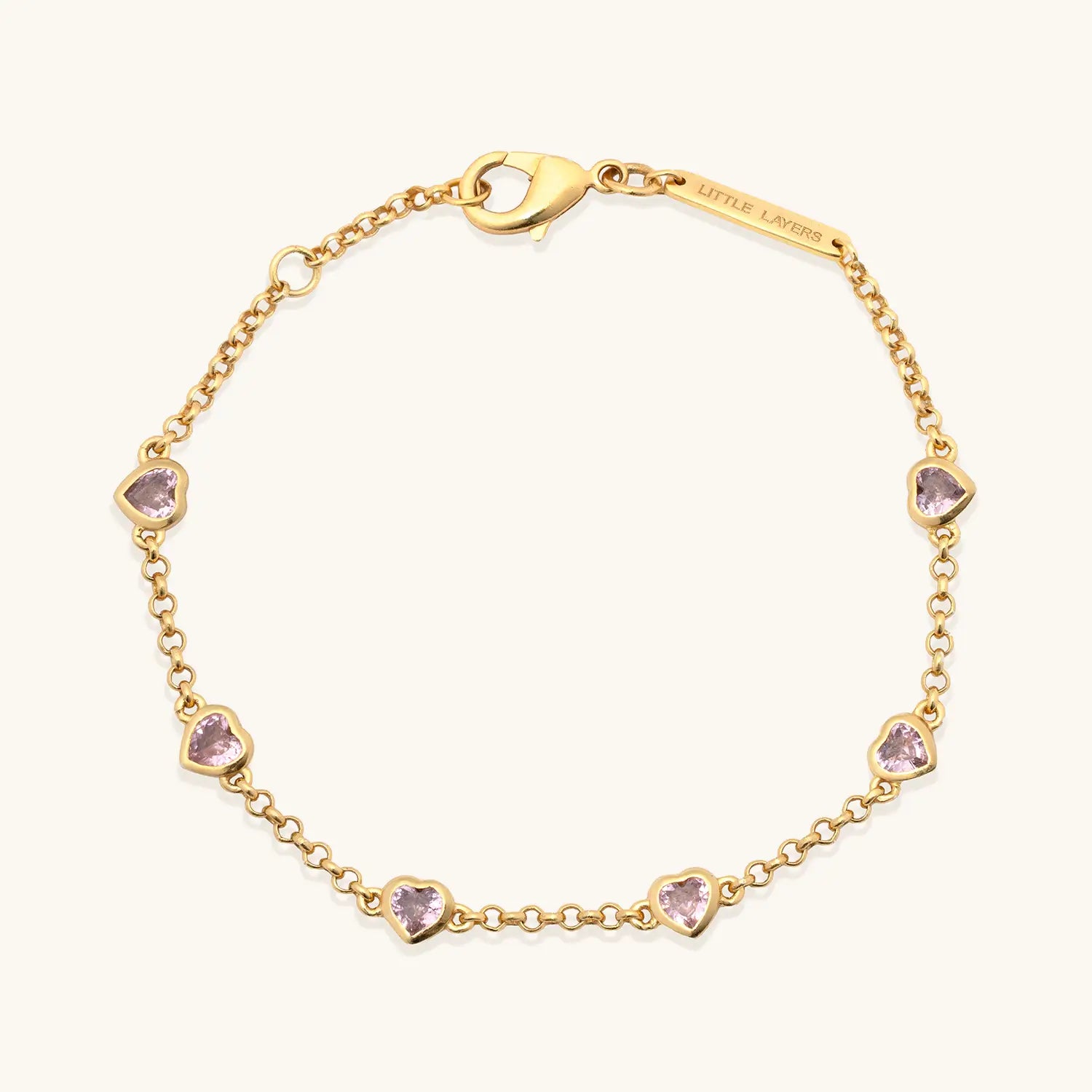 Gold bracelet with heart-shaped gemstones on a white background