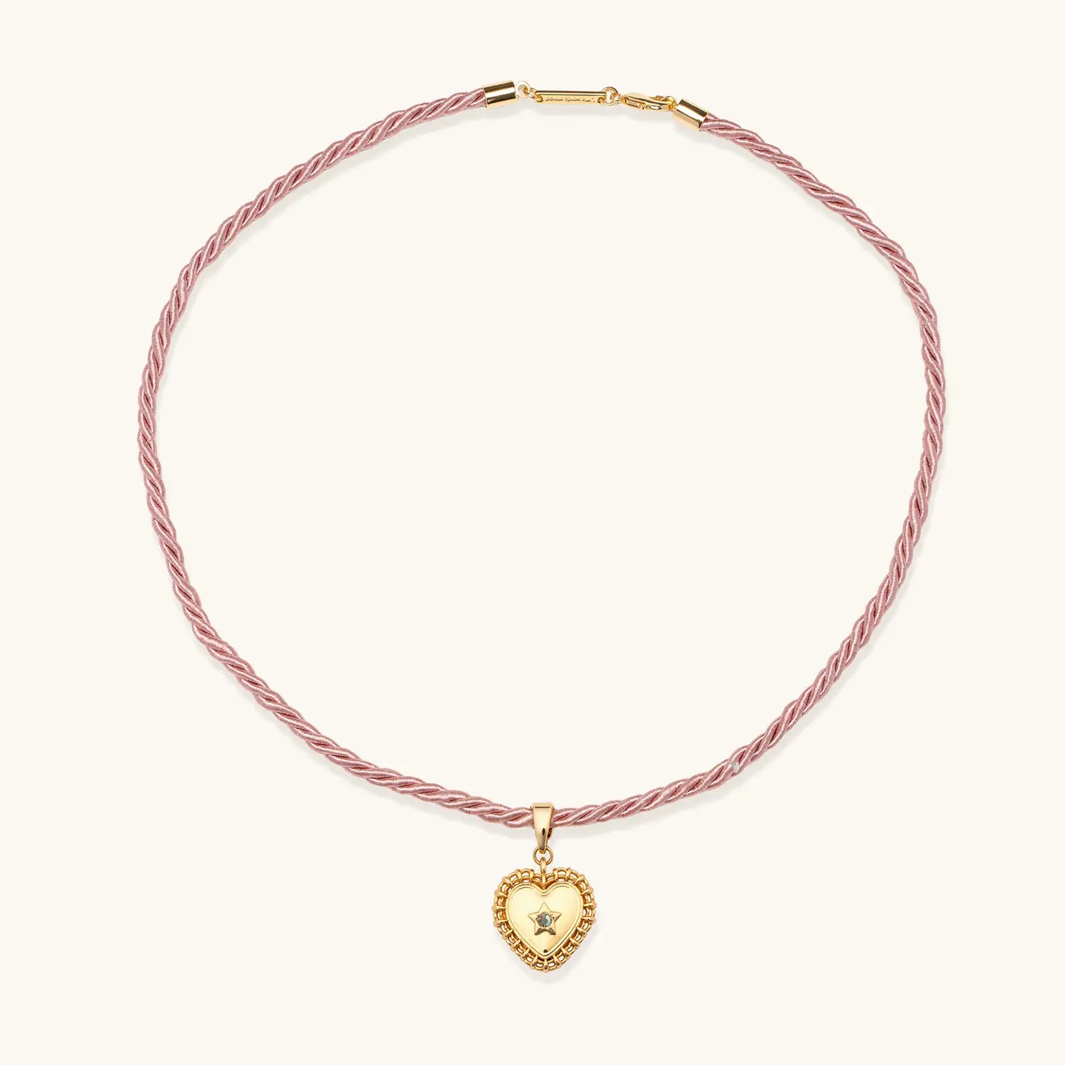 Pink braided necklace with a gold heart-shaped pendant on a white background