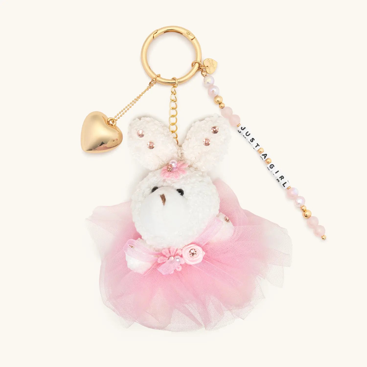Plush keychain with pink skirt and gold heart charm on a white background
