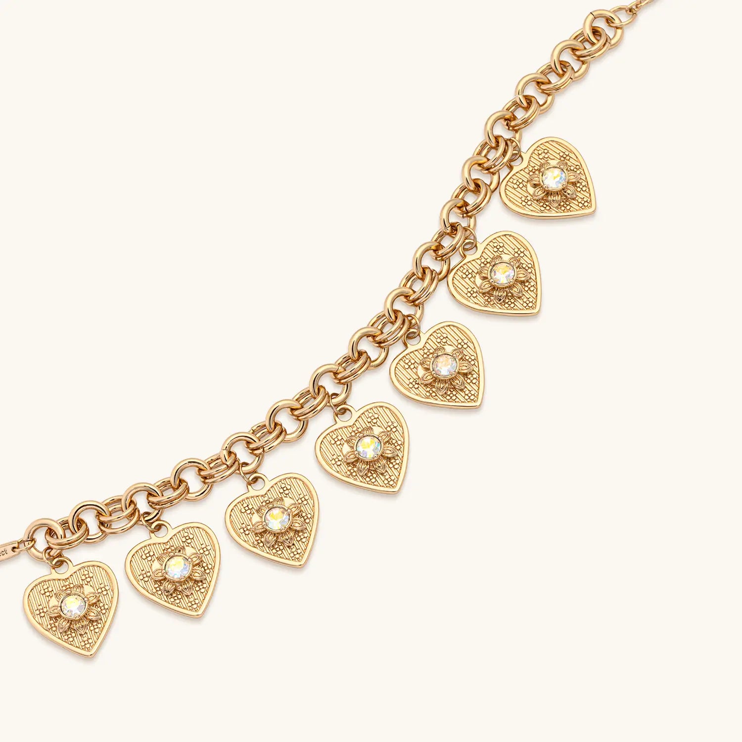 Gold bracelet with heart-shaped charms on a white background