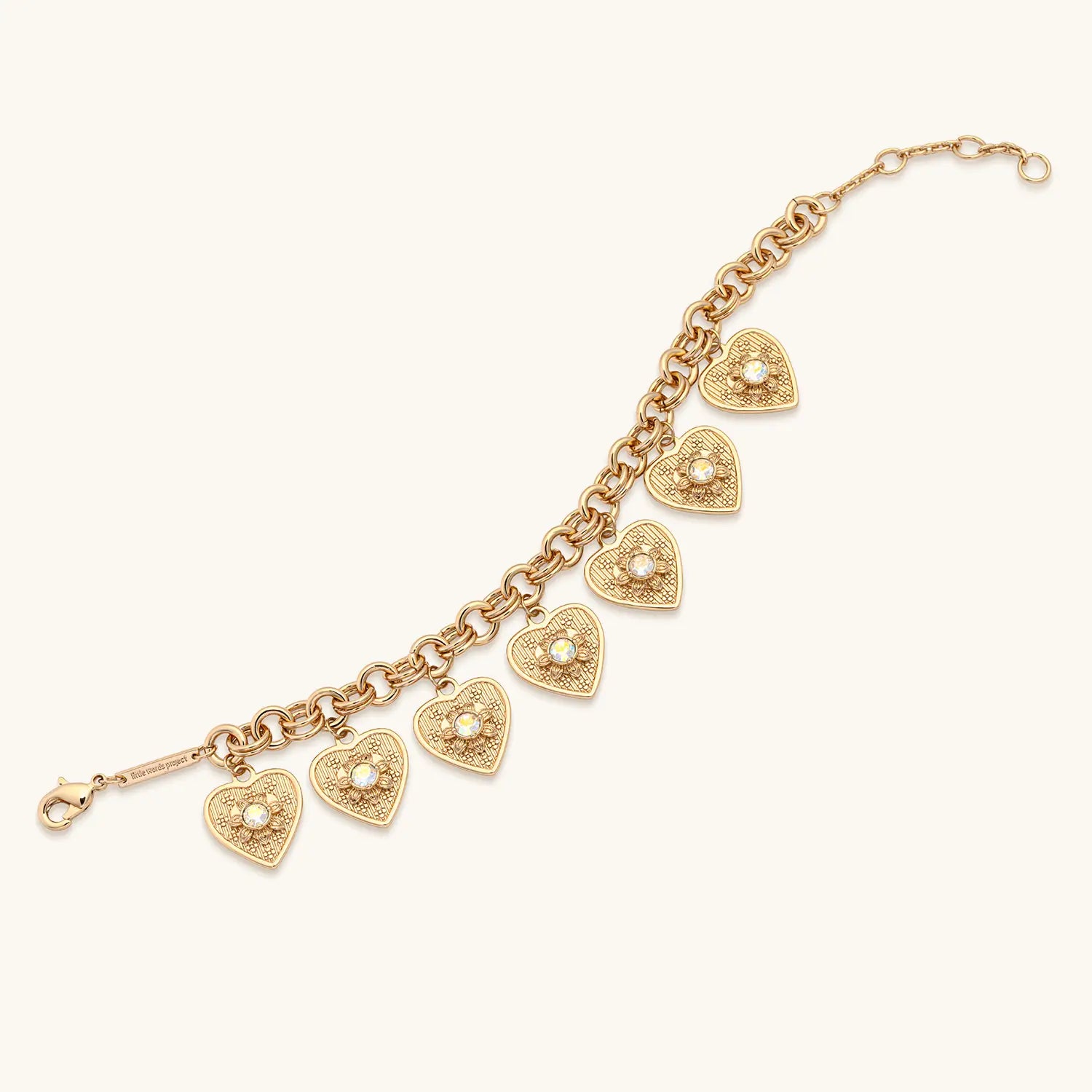 Gold bracelet with heart-shaped charms on a white background
