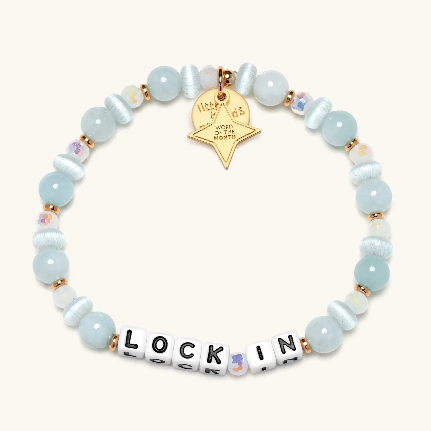 Bracelet with light blue beads and a gold tag on a white background