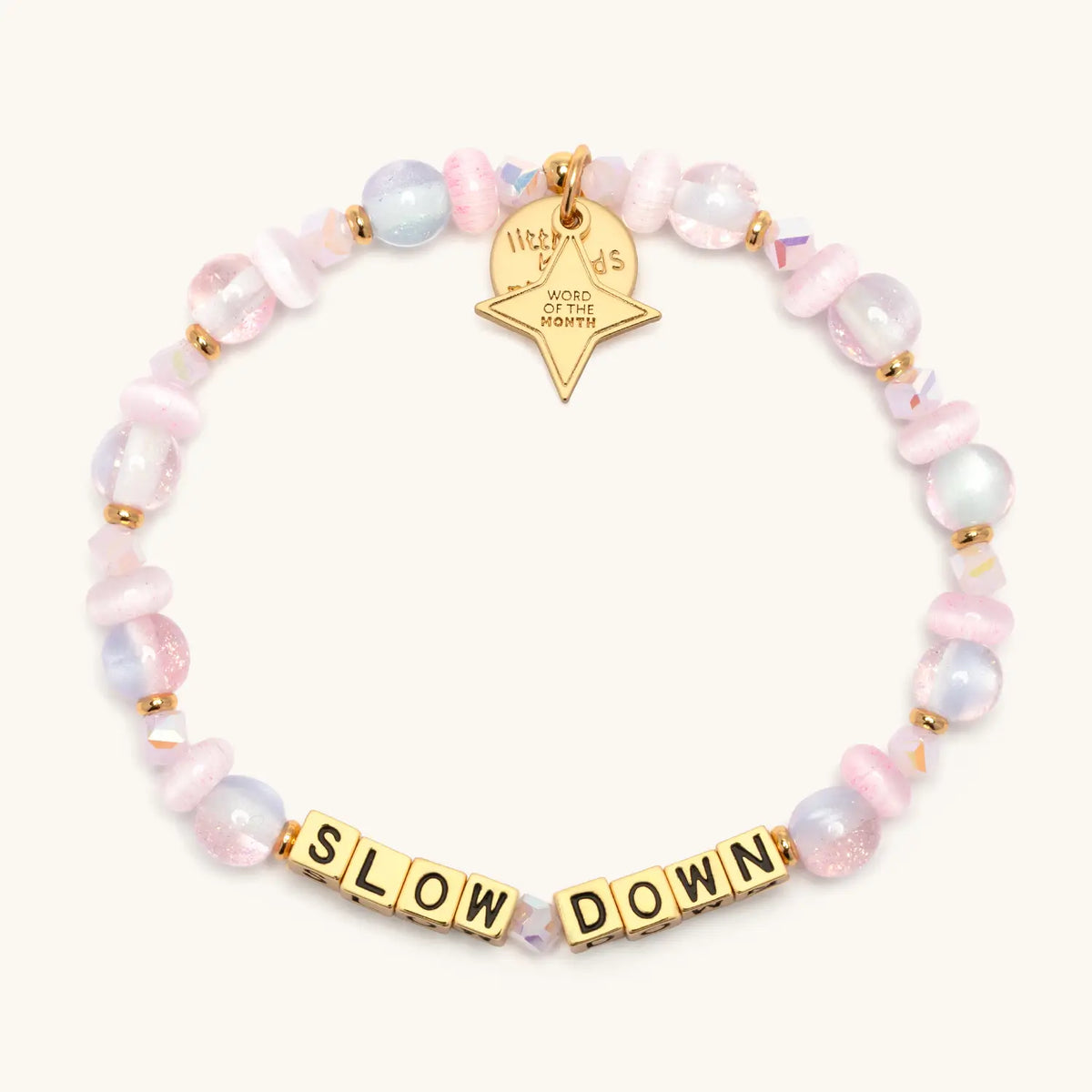 Slow Down October Word of the Month bracelet with gold letter beads, pale pink glitter glass, cat eye, and iridescent crystal beads, gold spacers, and a gold star Word of the Month charm, flat-lay