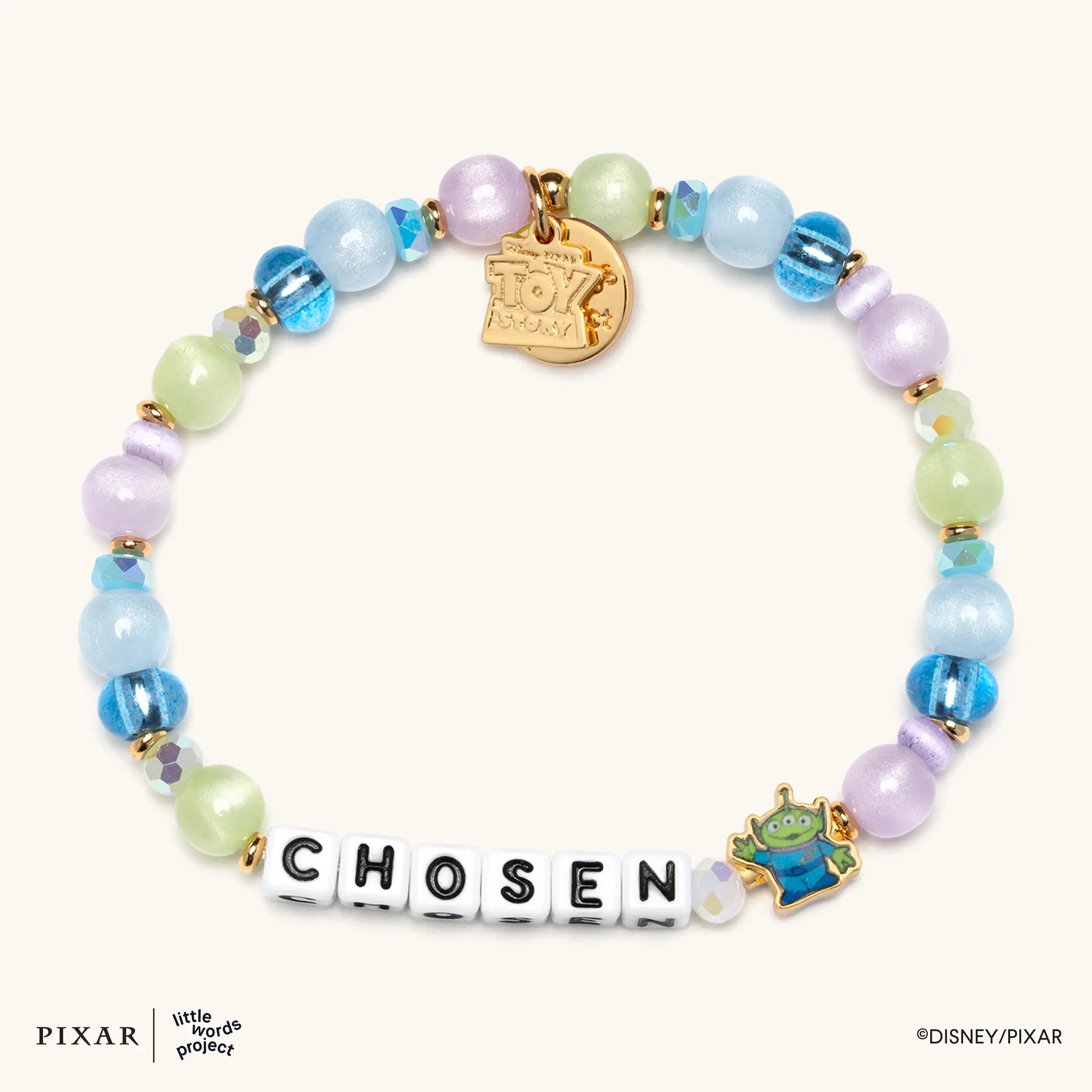 Chosen Toy Story bracelet, pastel blue, green and purple beads spelling CHOSEN with a gold charm and green alien bead, flat lay