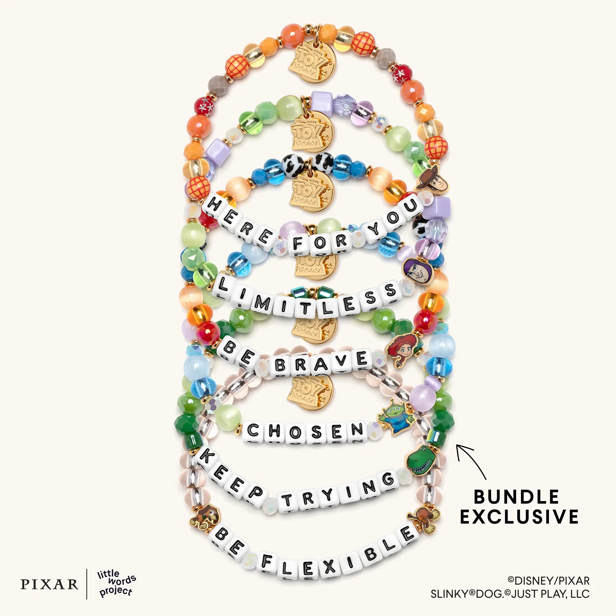 Deluxe Toy Story set of six bracelets with gold charms, flat lay on cream