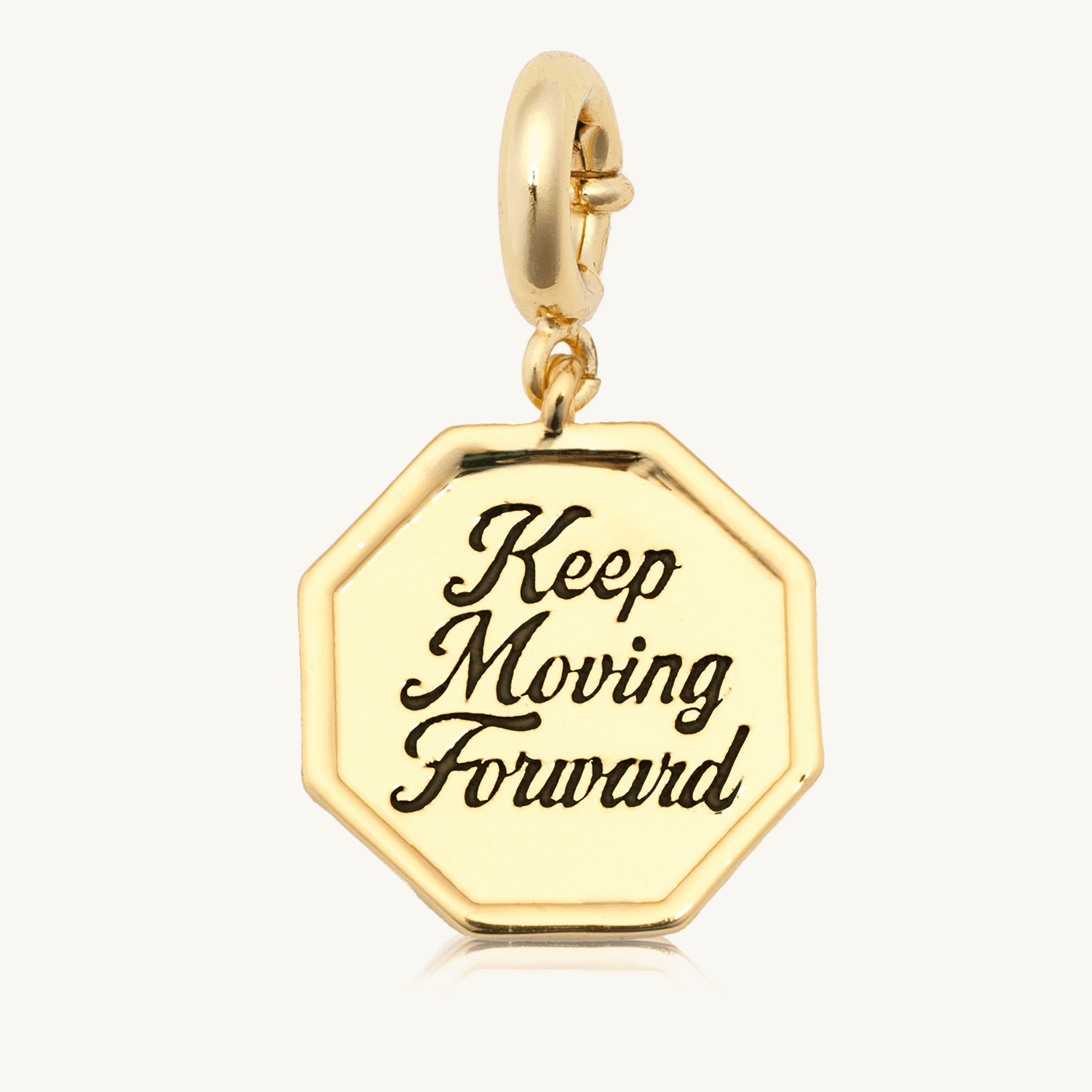 Keep Moving Forward Charm animation flipping the 18k gold-plated octagon medallion between the engraved Keep Moving Forward front and the bow and arrow back, on cream background