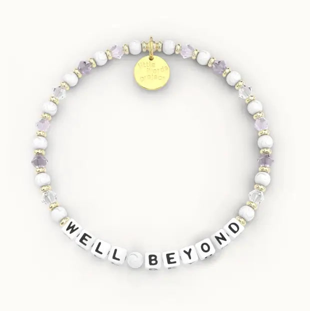 Giveback Well Beyond bracelet with white and lavender amethyst crystal beads, gold hardware, flat-lay product shot