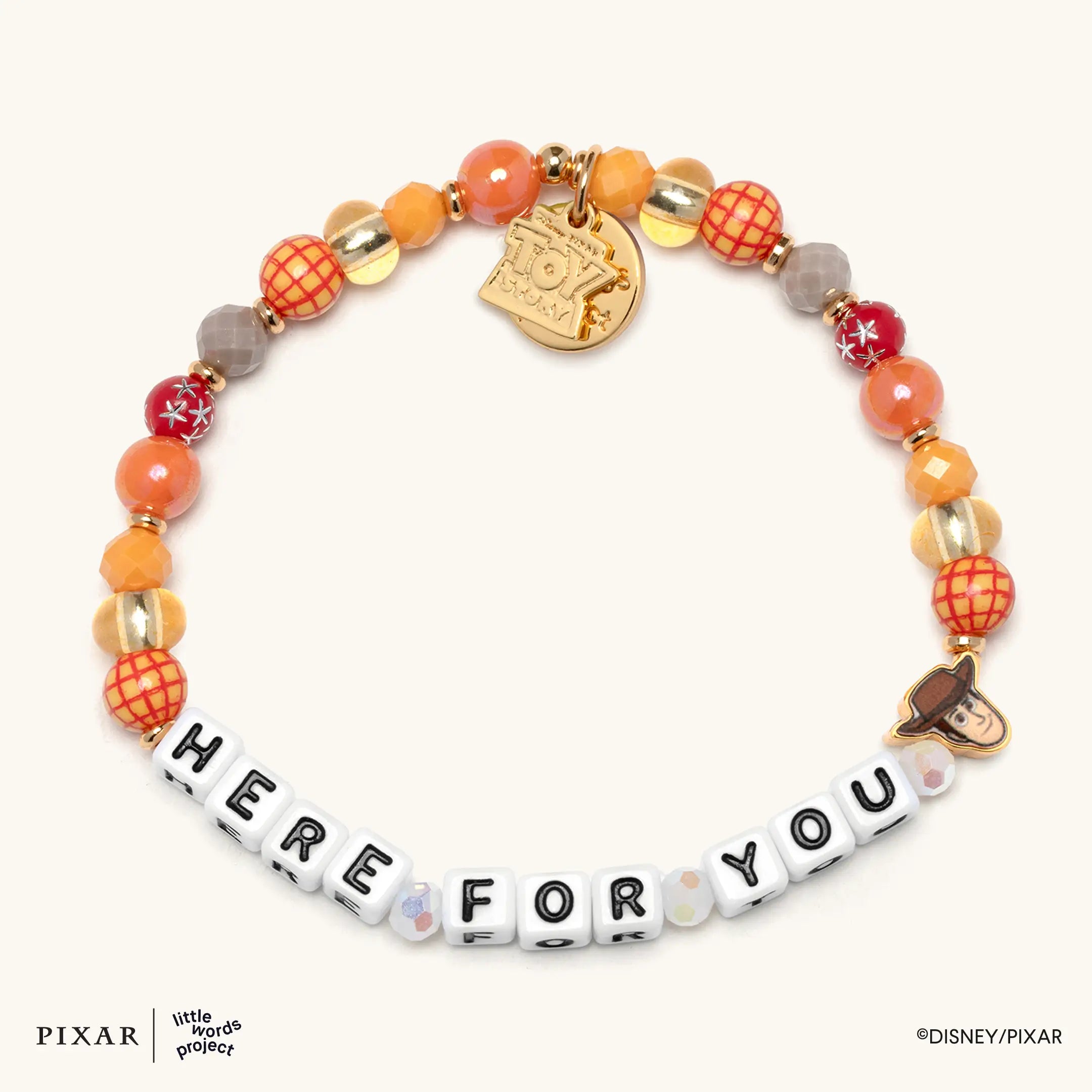 Here For You Toy Story bracelet, orange, red and gold beads spelling HERE FOR YOU with a gold Woody charm, flat lay
