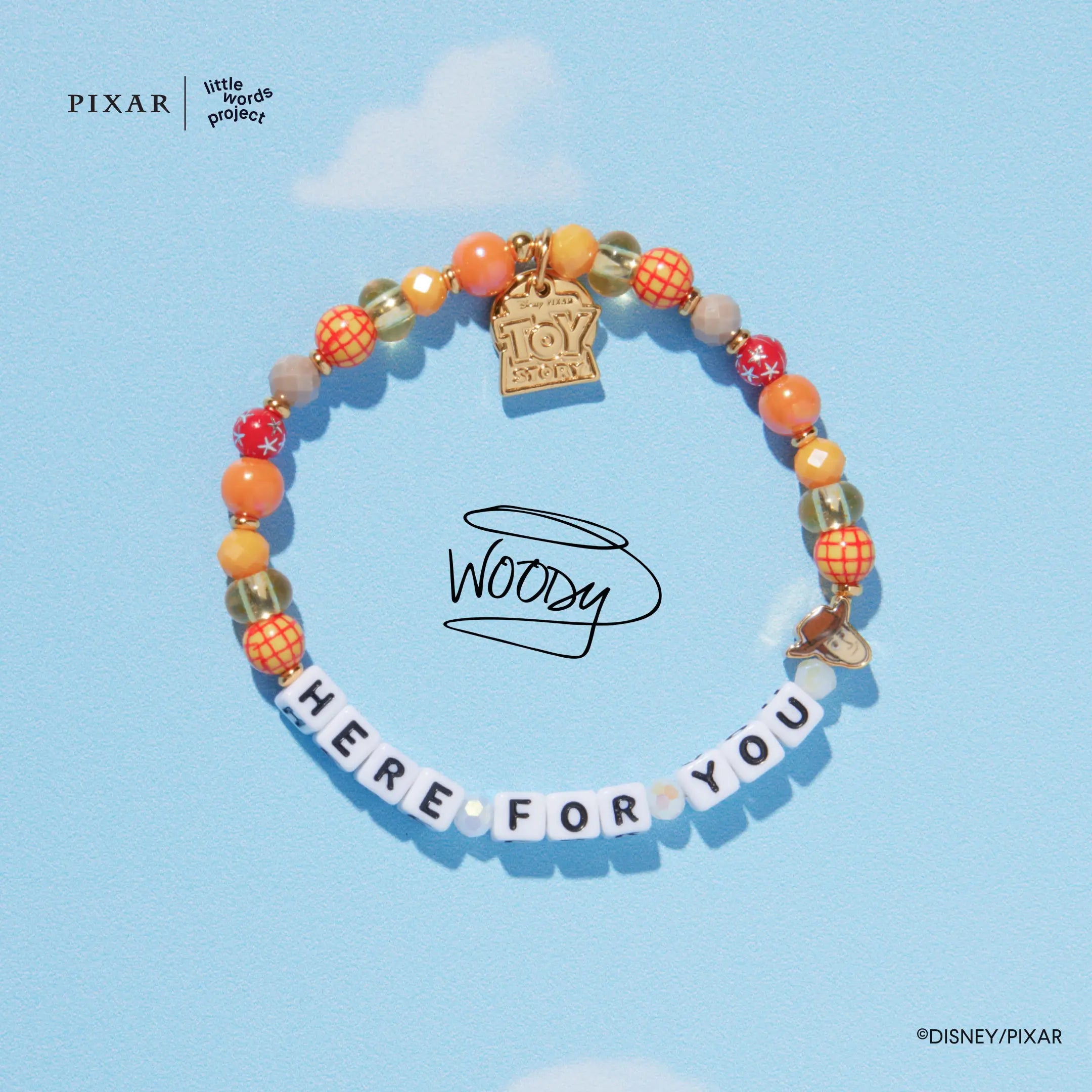 Here For You Toy Story bracelet with a gold charm on a blue sky background with a Woody signature