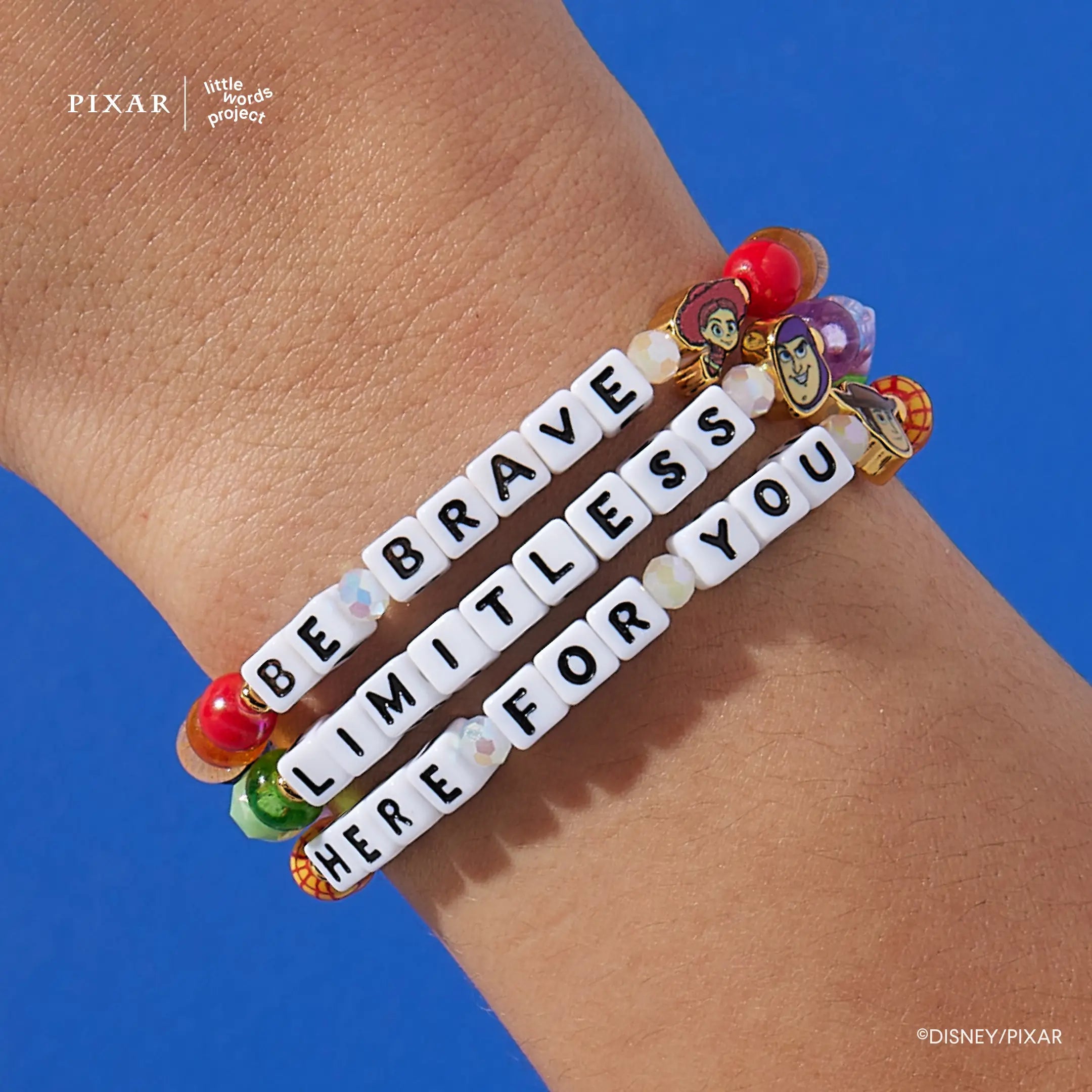 Here For You, Limitless and Be Brave Toy Story bracelets stacked on a model's wrist