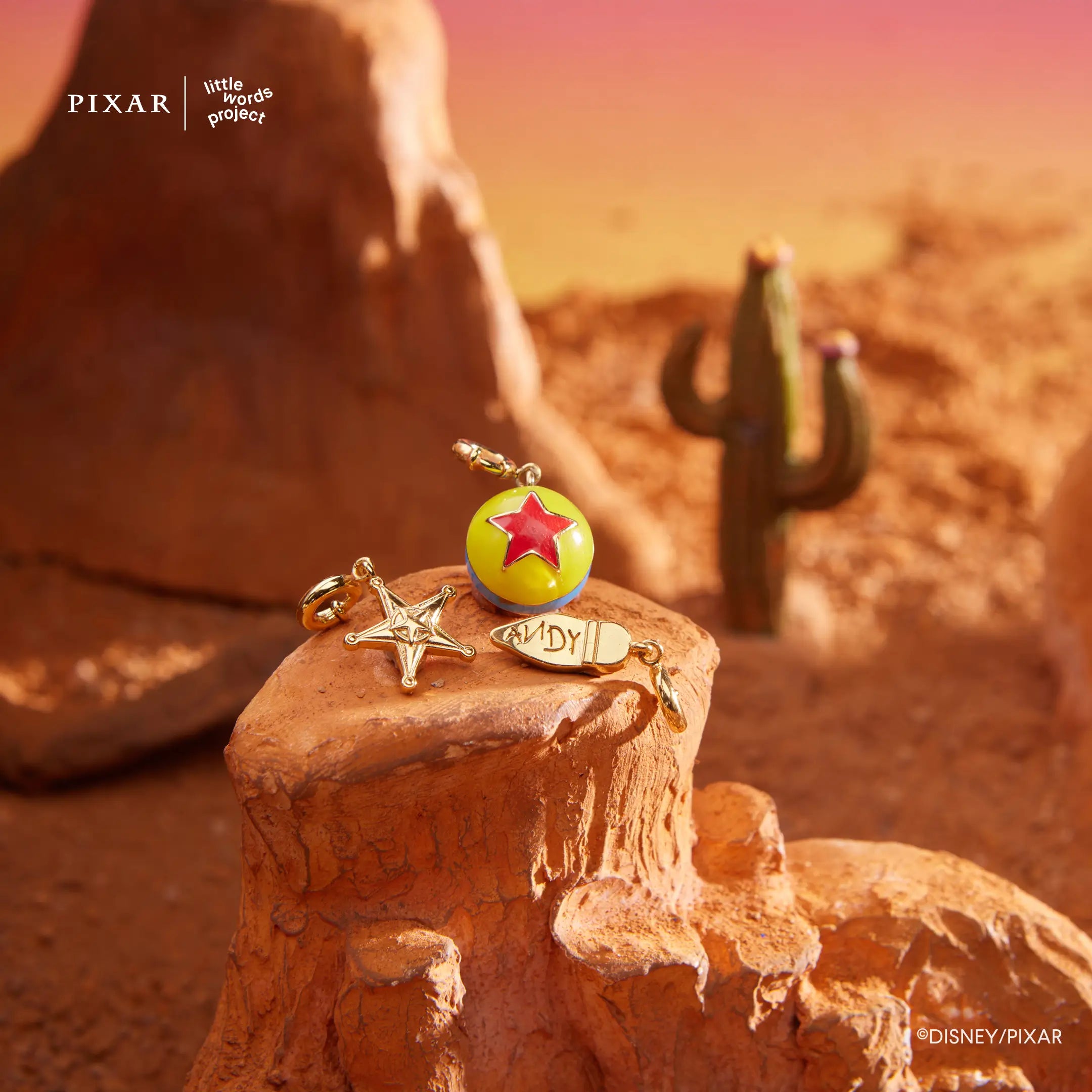 Reach for the Sky Toy Story charms styled in a desert scene with boot, star and Pixar ball charms