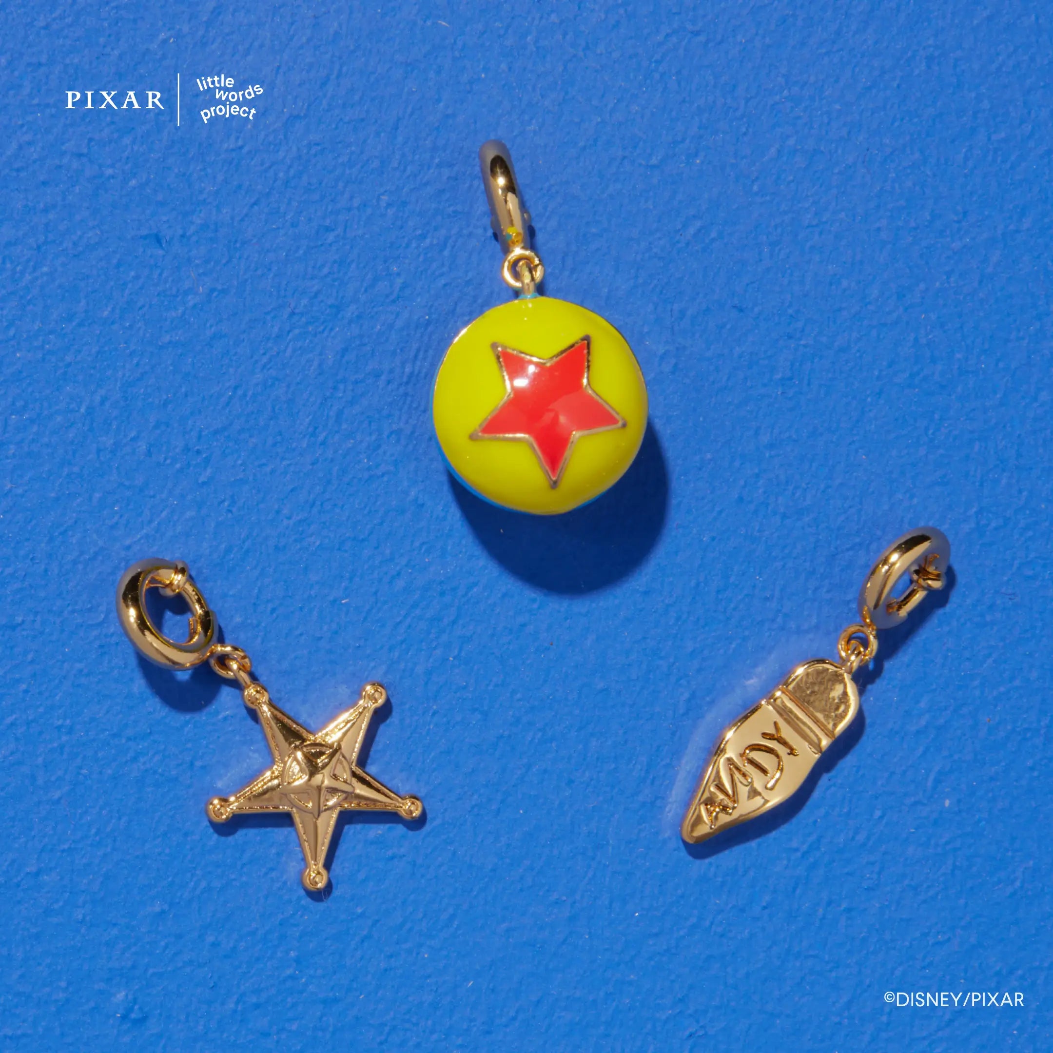 Reach for the Sky Toy Story charm trio, sheriff star, Pixar ball and Woody boot charms on blue