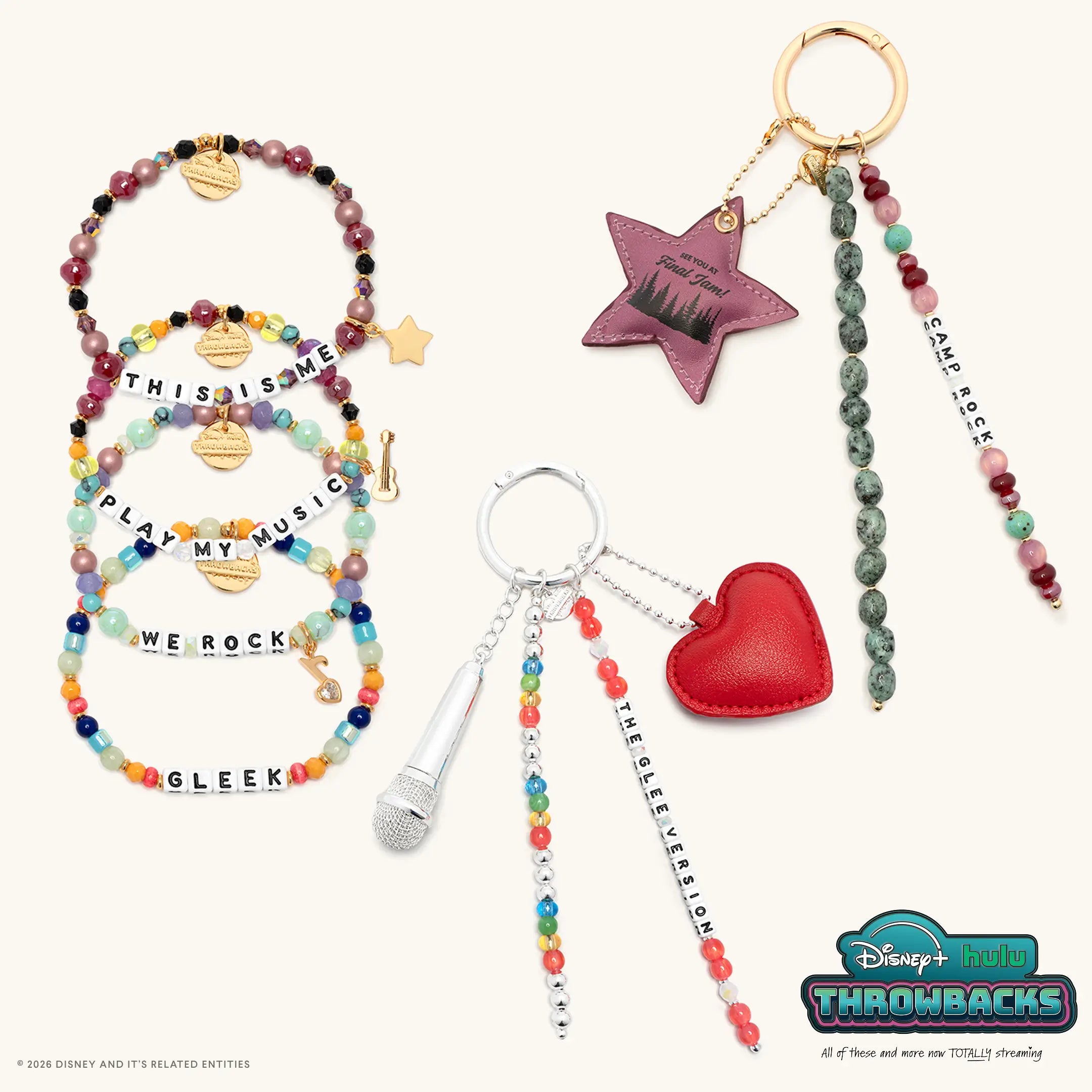 Throwback Set from Disney+ Hulu Throwbacks with all six pieces: the This Is Me, Play My Music, We Rock, and Gleek bracelets plus the Camp Rock and The Glee Version bag charms, flat lay on cream